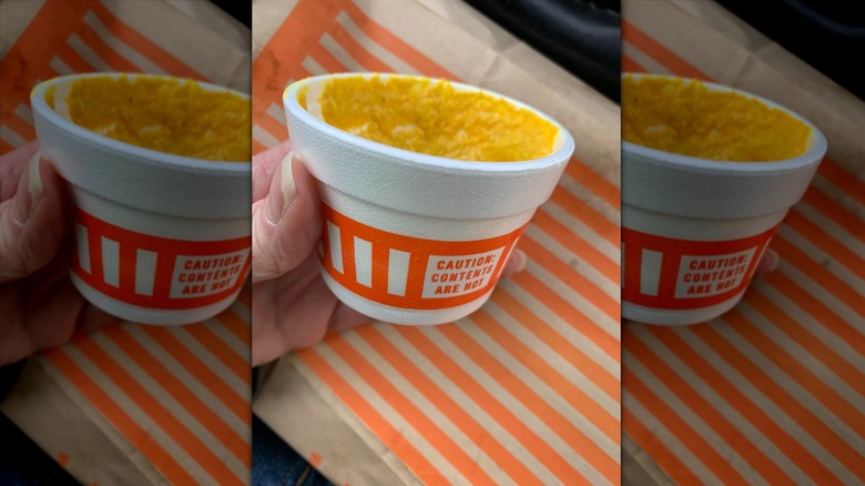 Hand holding cup of mustard at Whataburger