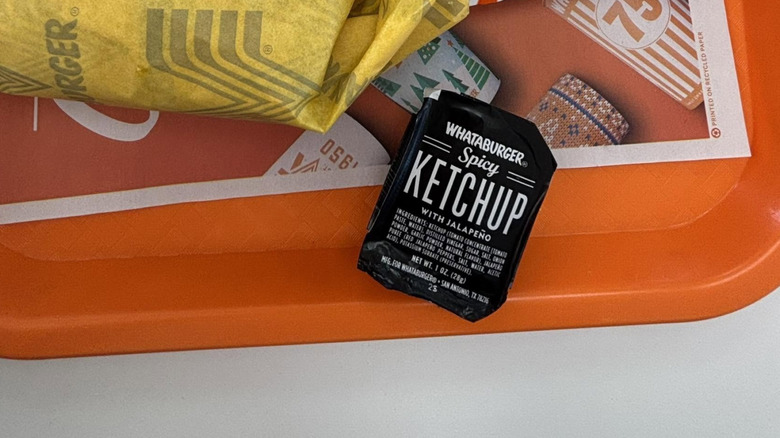 Packet of Whataburger spicy ketchup on orange tray