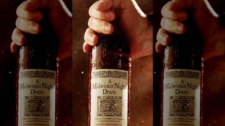 mirrored image of a hand holding a bottle of High West A Midwinter Night's Dram