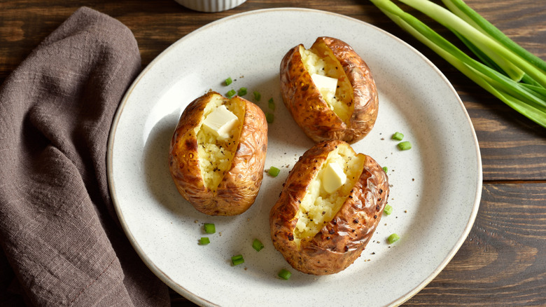 Baked potatoes with butter on a white plate