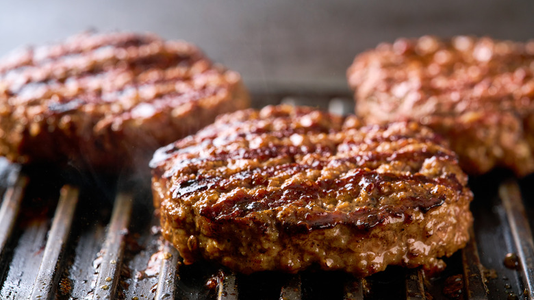 burger patties cooking on a grill