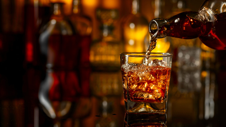 Bourbon being poured from a bottle into a shot glass