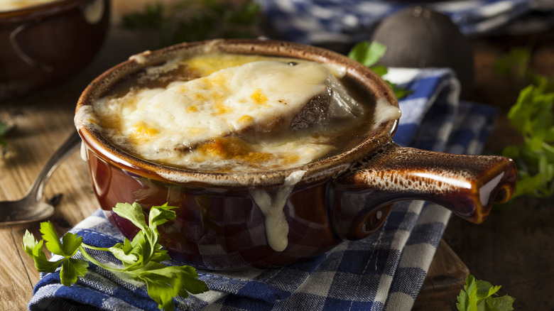 Bowl of French onion soup on cutting board