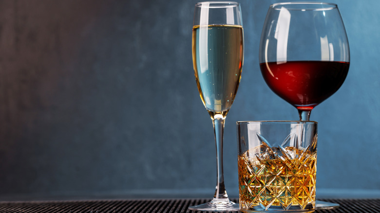 Three glasses with wine, whiskey, and champagne