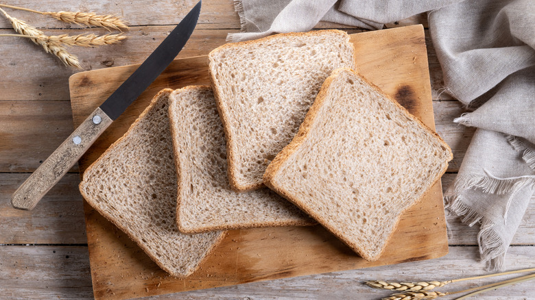 Slices of bread on a board with a knife