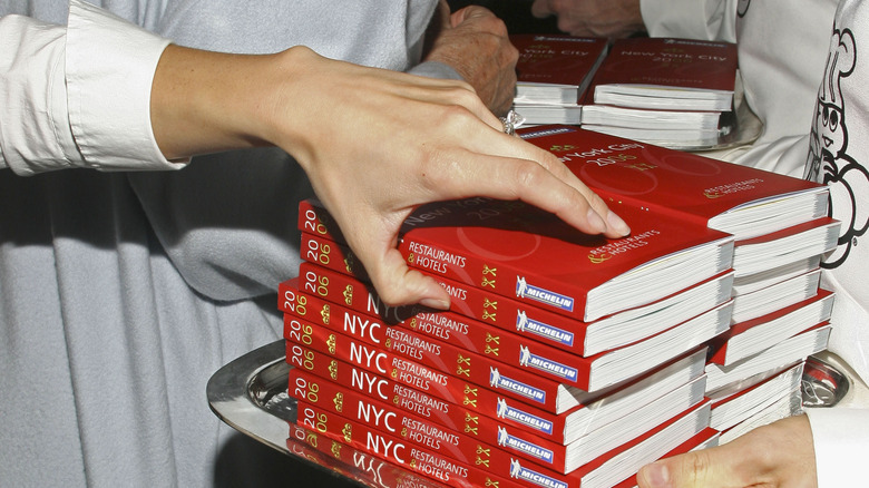 Person picks up a Michelin guide at a bookshop