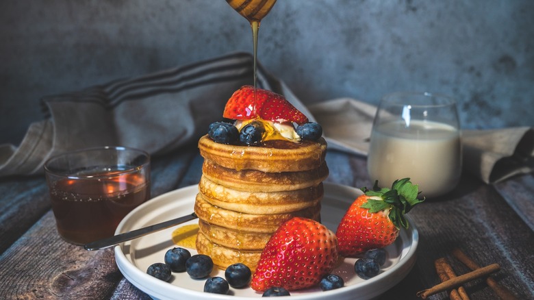 Pancakes with pouring honey on plate