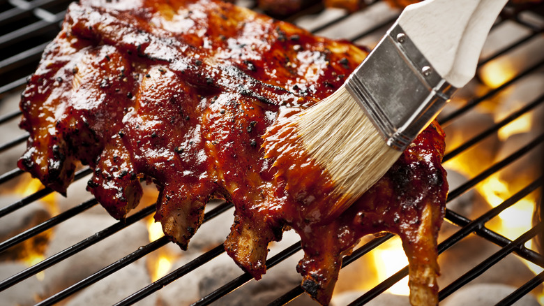 brushing ribs with barbecue sauce
