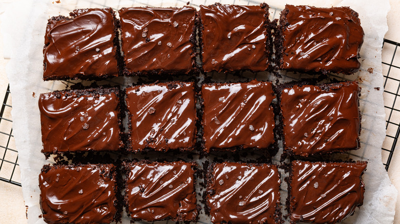 A chocolate dump cake topped with chocolate frosting and sea salt cut into squares