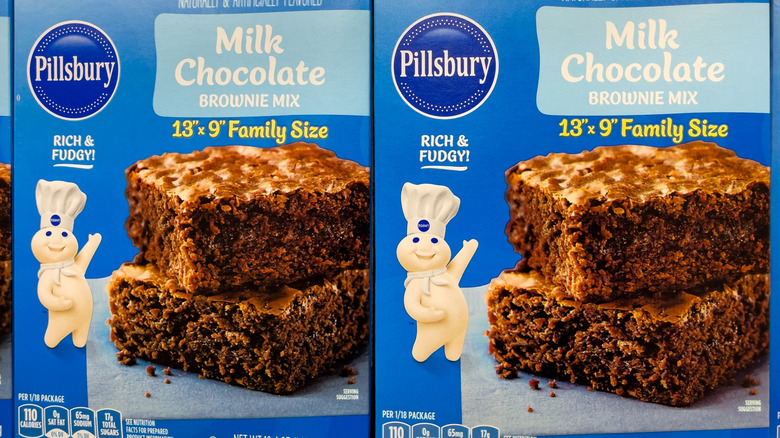 A stack of brownie mix pancakes on a plate with fresh banana slices and blueberries