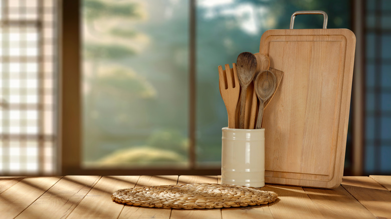 Wooden utensils and cutting board on a wooden table