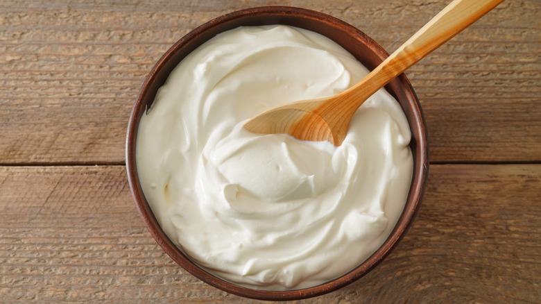 wooden bowl of cream cheese with small wooden spoon