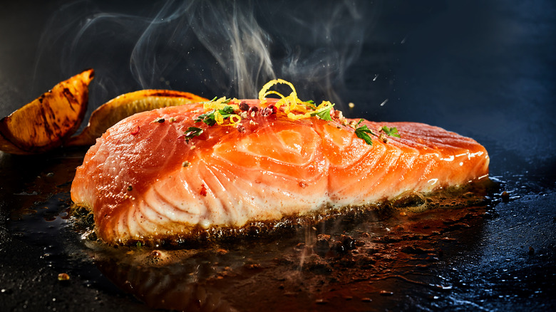 Salmon cooking on griddle.