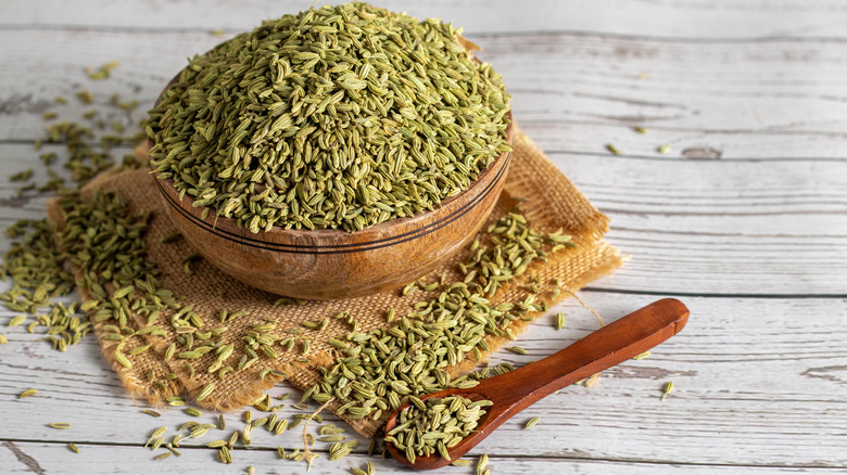 An overflowing bowl and spoon of fennel seeds