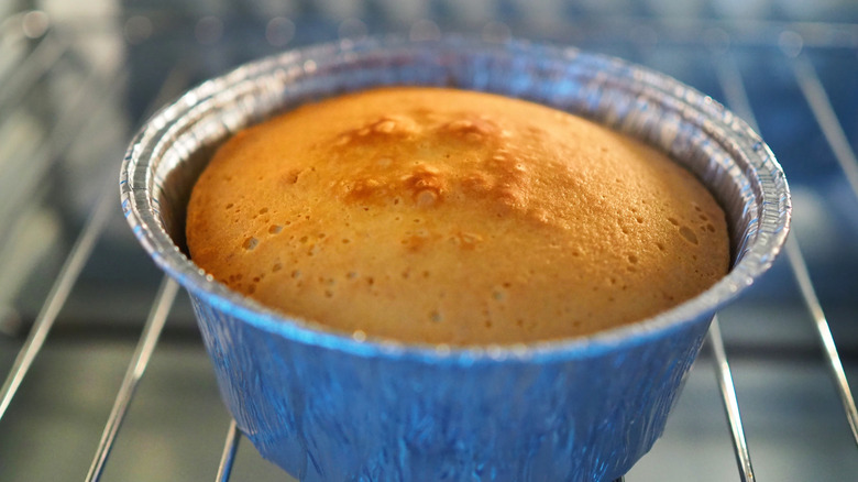 Cake in foil cup in oven