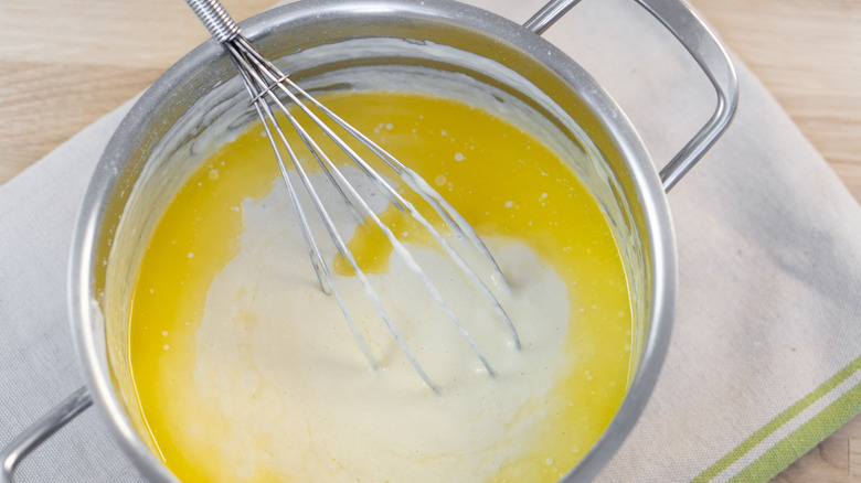 whisking milk and melted butter in saucepan