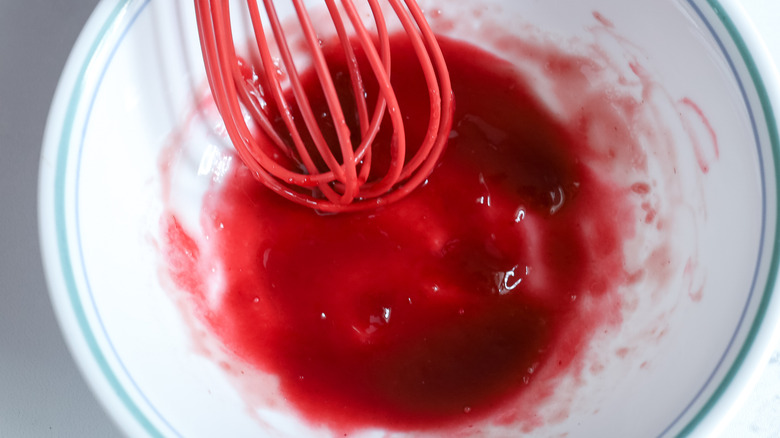 whisking raspberry jam and water