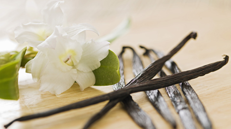 Vanilla beans with flower on table