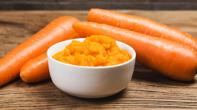 Mashed carrots with fresh carrots in the background