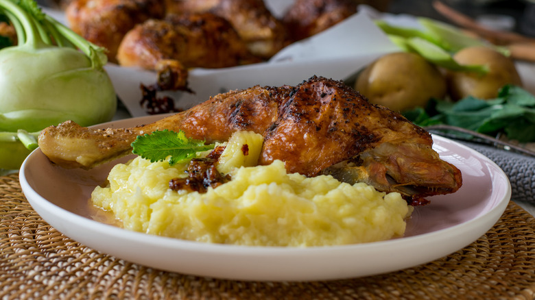 Mashed kohlrabi on a plate with roasted poultry