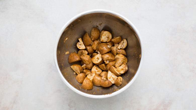 marinating mushrooms in metal bowl