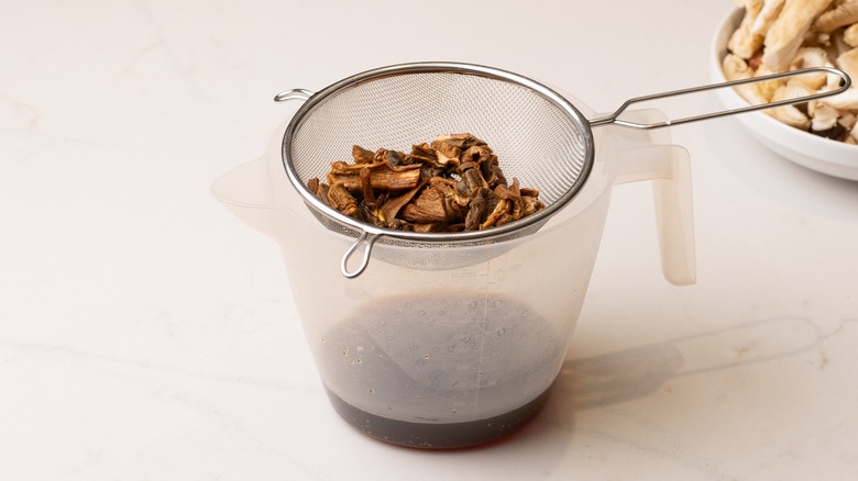 straining rehydrated porcini mushrooms