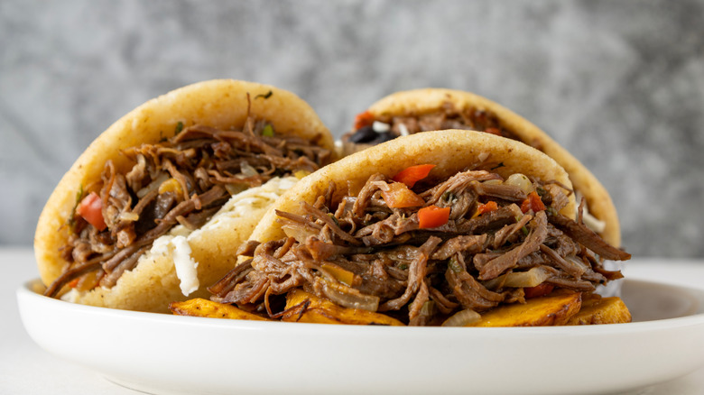 Plate of Venezuelan arepas stuffed with shredded beef and vegetables