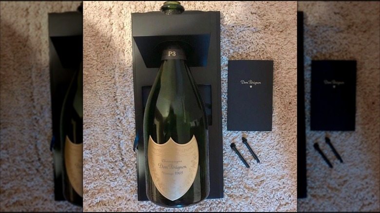mirrored image of Dom Pérignon Bottle in packaging on carpet