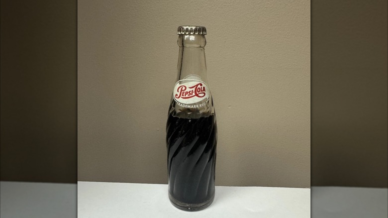mirrored image of vintage Pepsi bottle against brown wall