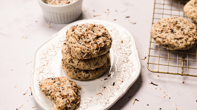 Stack of coconut cookies with more on cookie rack