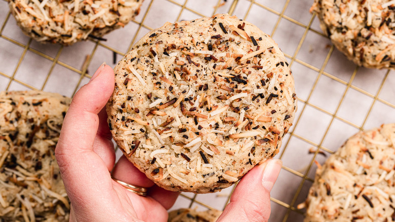 Hand holding a cookie over the cookie rack