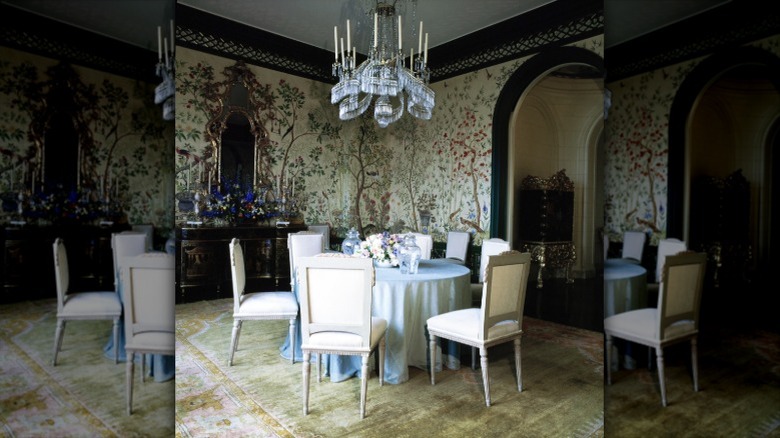 A dining room decorated with elaborate chinoiserie wallpaper and other chinoiserie design elements.