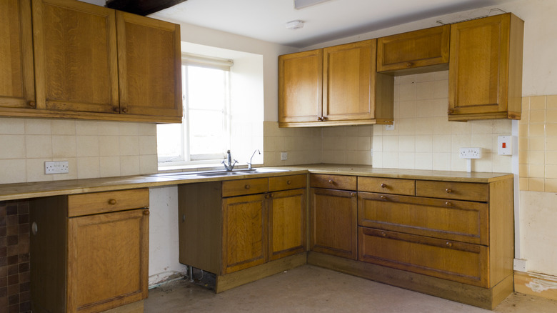 An empty kitchen with wooden cabinets