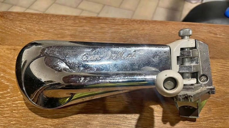A close-up photo of a wall-mounted can opener