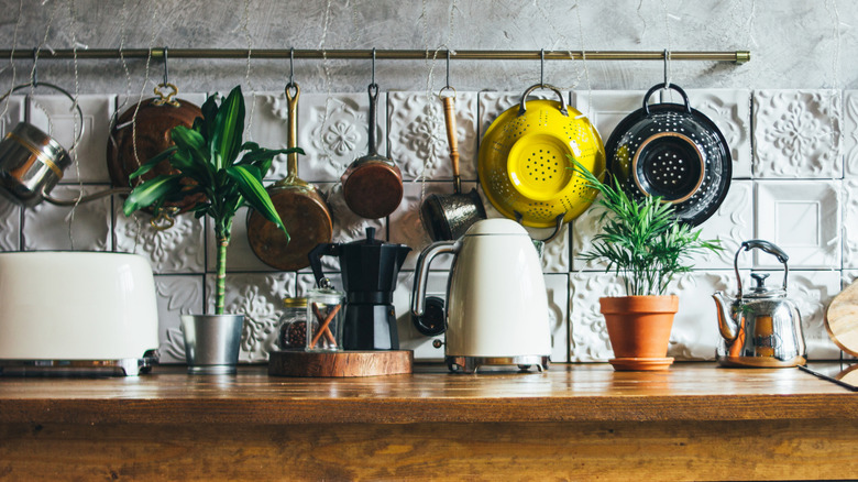 A mix of vintage and modern kitchen items displayed in front of an ornate white tiled backsplash.