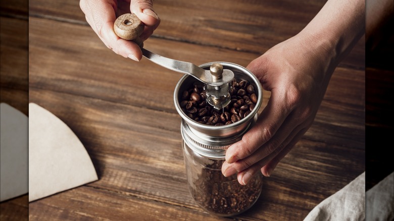 Coffee beans inside a manual coffee grinder.