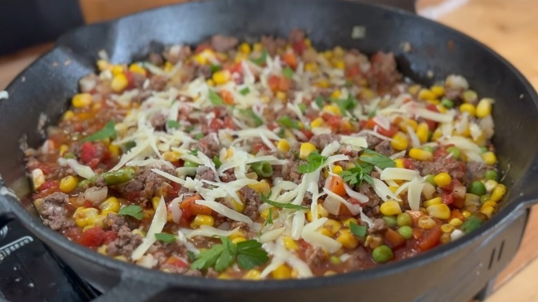 Shipwreck casserole with ground beef, cheese, and vegetables in skillet