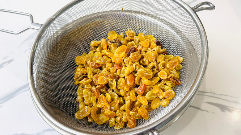 Golden raisins in mesh strainer