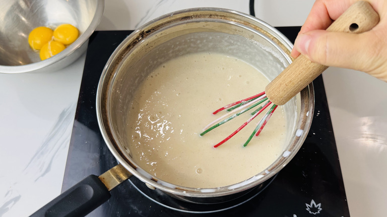 Whisking creamy pie filling in saucepan
