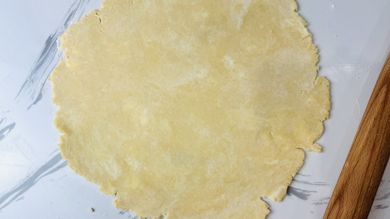 Rolled out pie dough on a floured surface