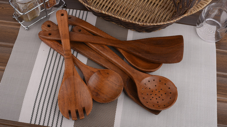 Teak wood utensils scattered on placemat