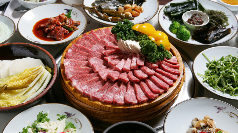 Hanwoo beef for Korean barbecue surrounded by other Korean dishes.