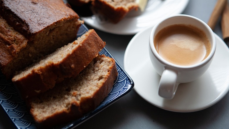 Sliced loaf of banana bread and a cup of coffee