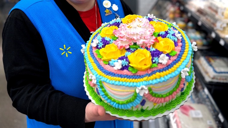 Walmart employee holding colorful custom cake