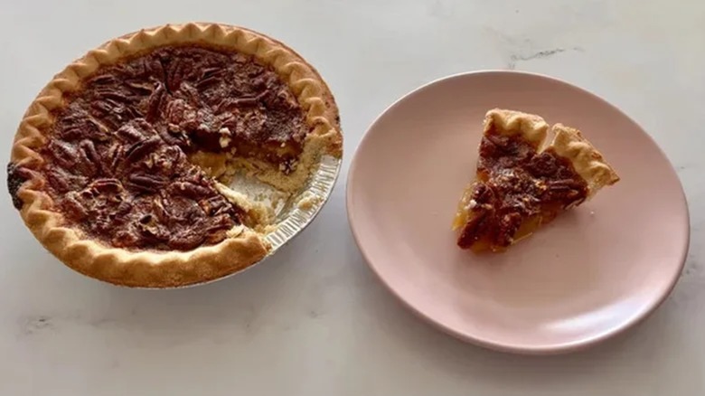 Pecan pie with one slice on a plate