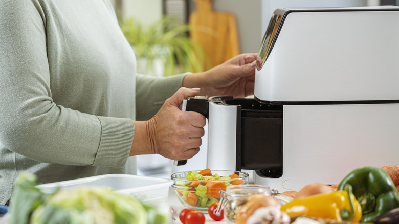 person using white air fryer