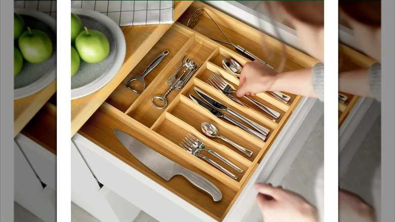 Royal Craft Wood Luxury Bamboo Kitchen Drawer Organizer in a drawer with a person putting in forks