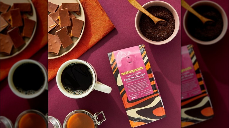 Bag of bettergoods caramel mocha coffee beside jar of caramel, plate of chocolate, mug of coffee, and bowl of grounds