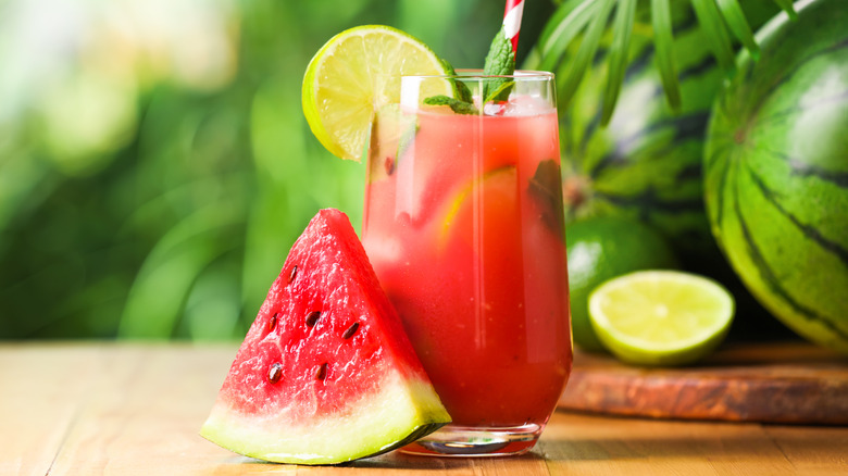 cup of watermelon drink with straw and slice of fruit