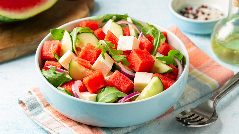 Watermelon salsa with herbs, cucumber and cheese in bowl
